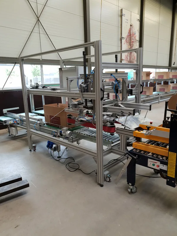 Aluminium frame met transportband en dozen